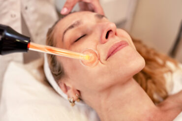 Middle aged woman having a high frequency facial cosmetic treatment, skin treatment concept